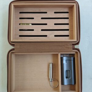 Travel humidor opened to show vented cedar grid tray and accessory compartment